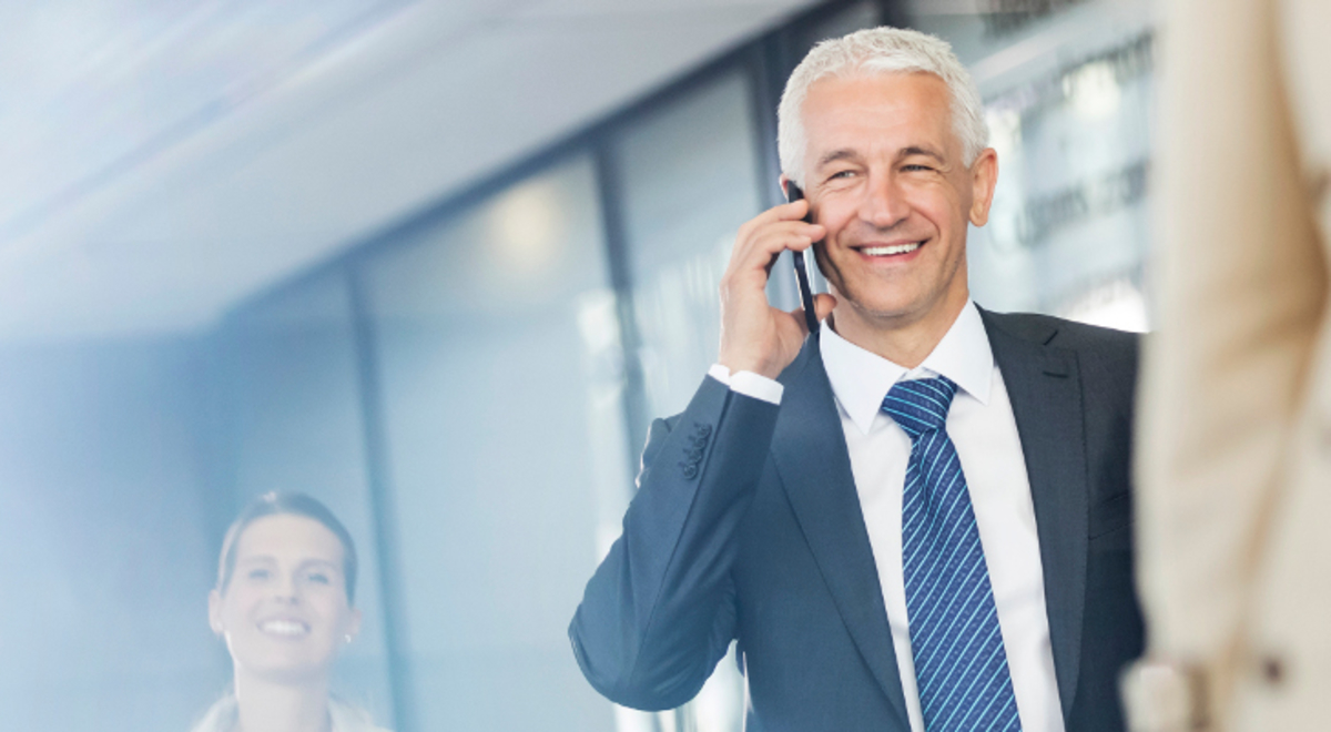 A man talking in his phone while smiling 