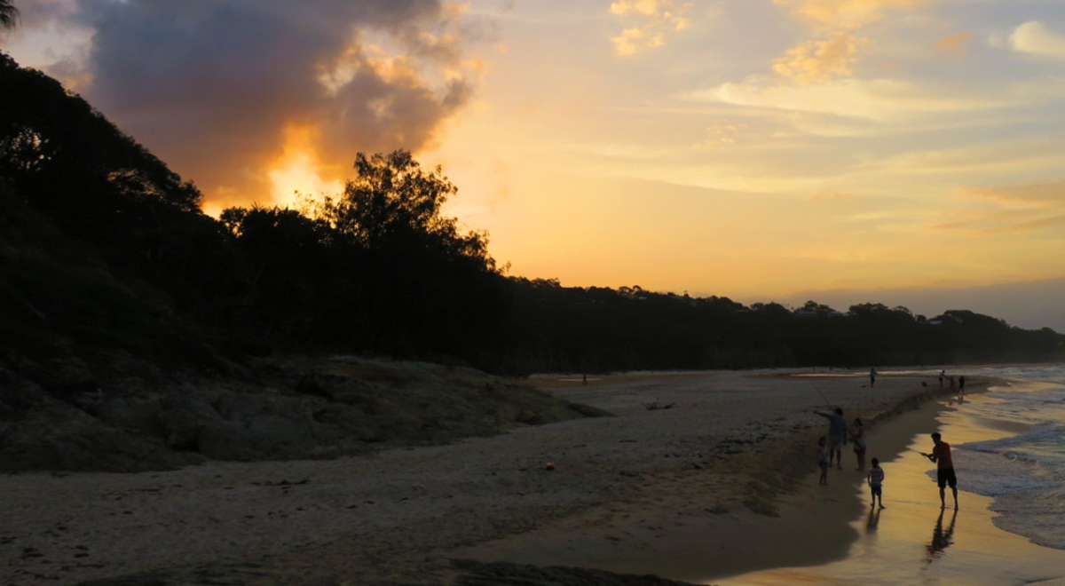 people fishing and having fun on the shore during sunrise