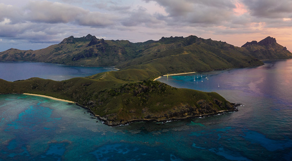 a green isolated island in the middle of the blue ocean