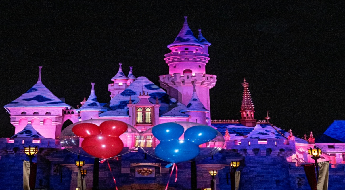 A castle with red and blue Mickey-Mouse-Ear balloons in front of it
