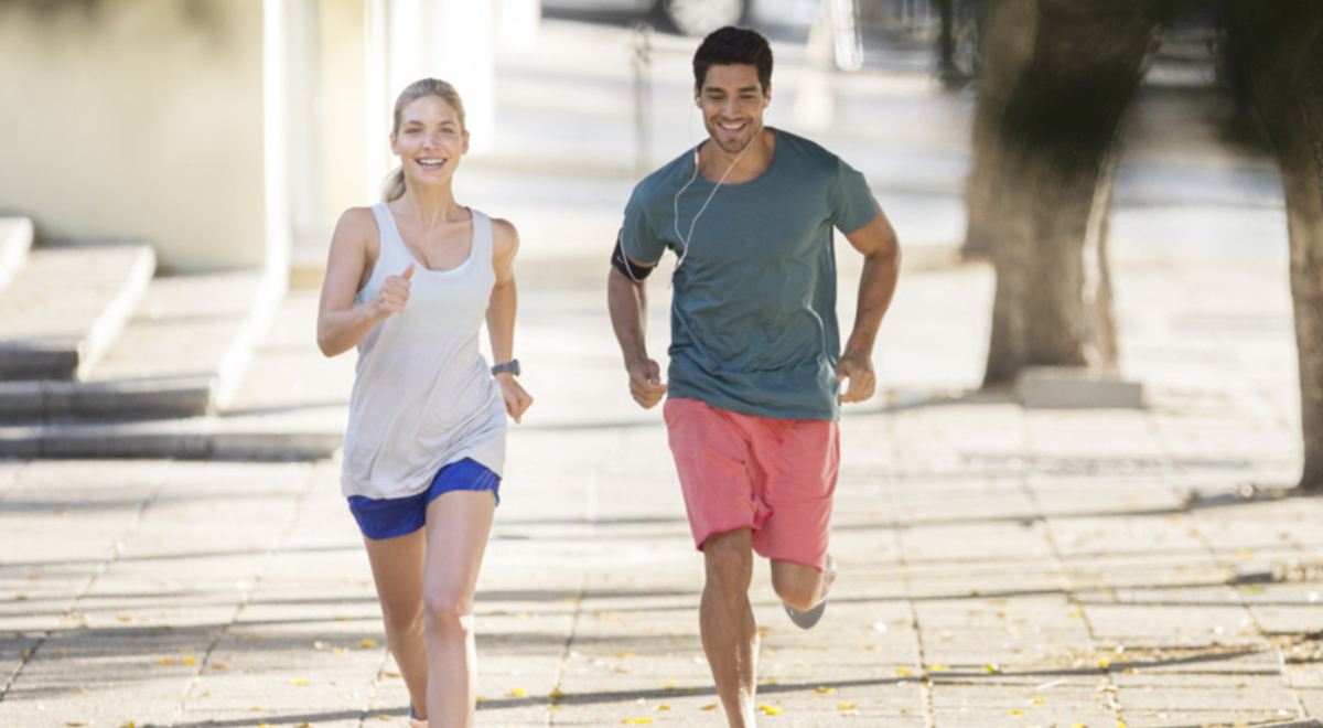 A man and a woman in jogging gear running down the street together