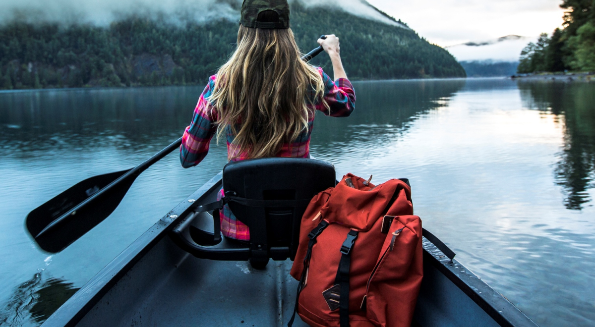 Lady sat in front of a boat rowing on a lake