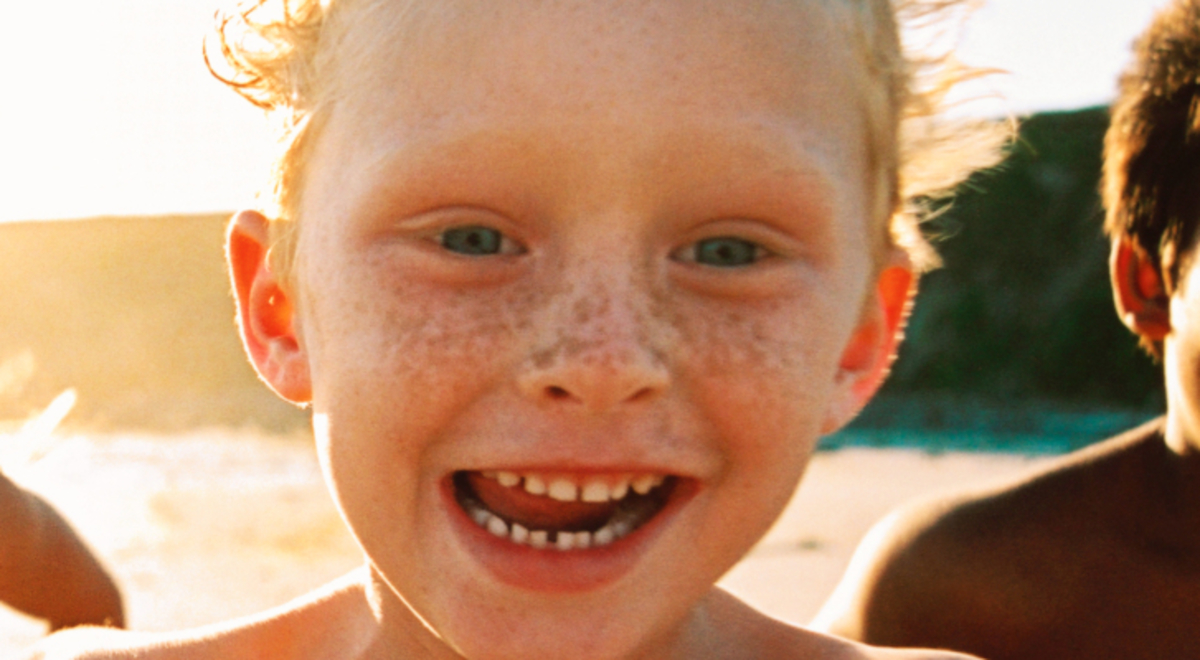 kids happily running on the beach during one sunny afternoon