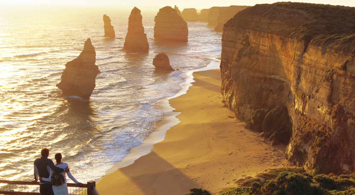 Couple enjoying the sunset on the mountain over the ocean shore