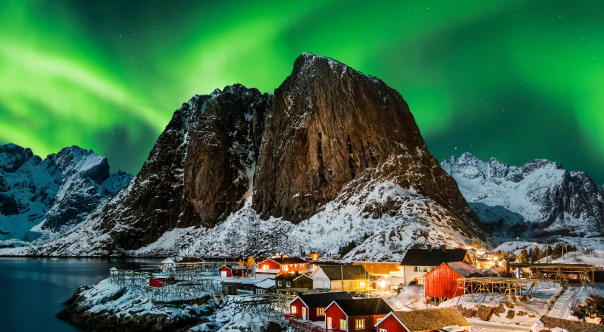 green aurora filling the skies on top of the mountain