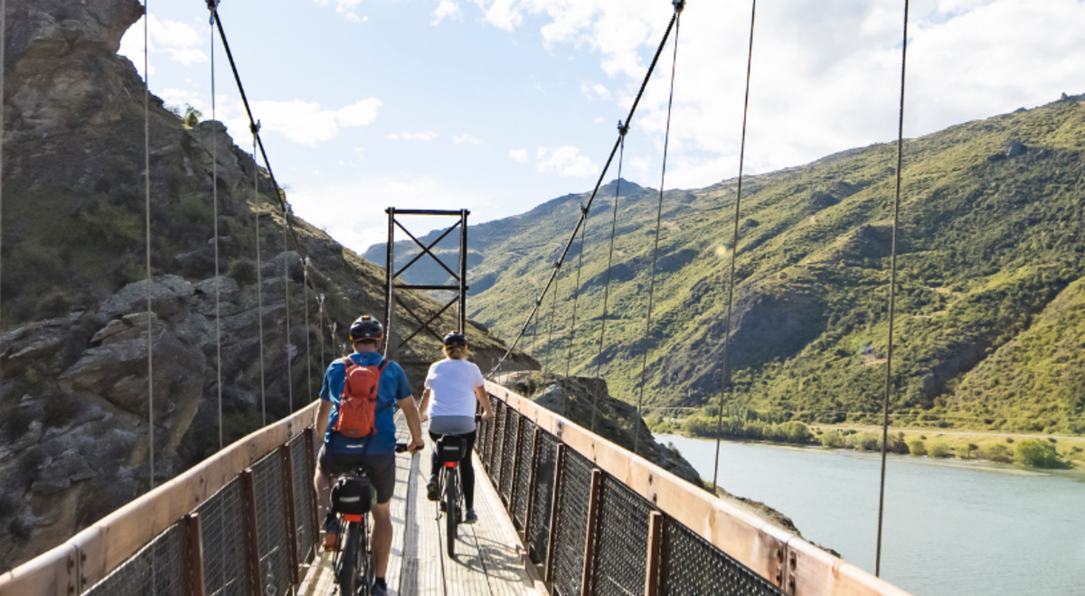 Two people bike riding over Lake Dunstan