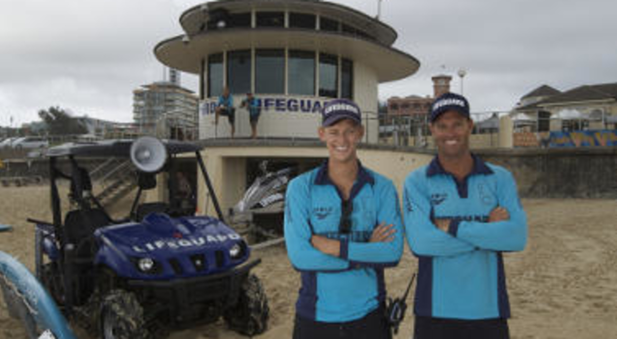 Two Bondi lifeguards in front of their tower