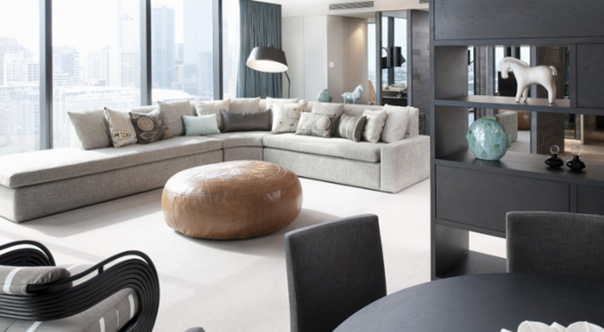 minimalistic living room with huge windows, L-shaped couch, and black dining table