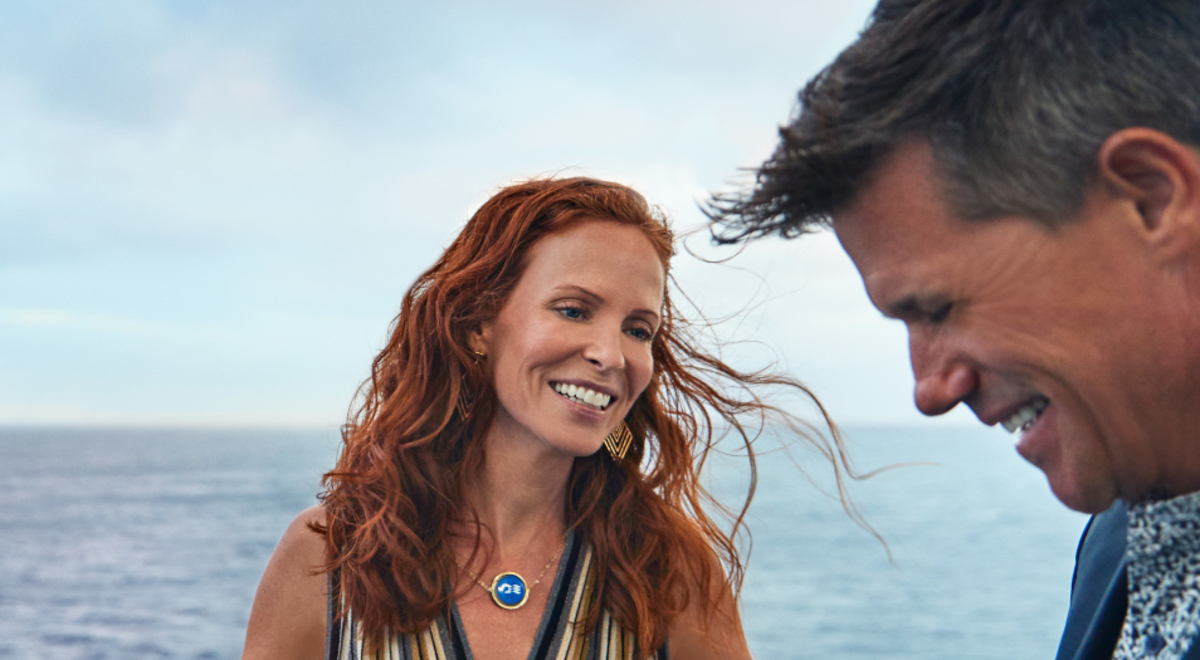 Lady happily staring at her partner by the sea