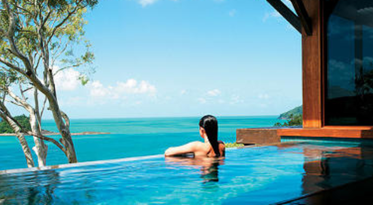 Woman enjoying infinity pool overlooking the ocean
