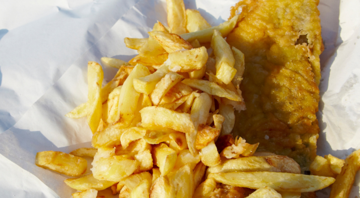 Fish and chips laid on a tissue on the ground