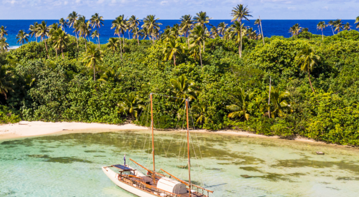Sailboat approaching the shore of an island