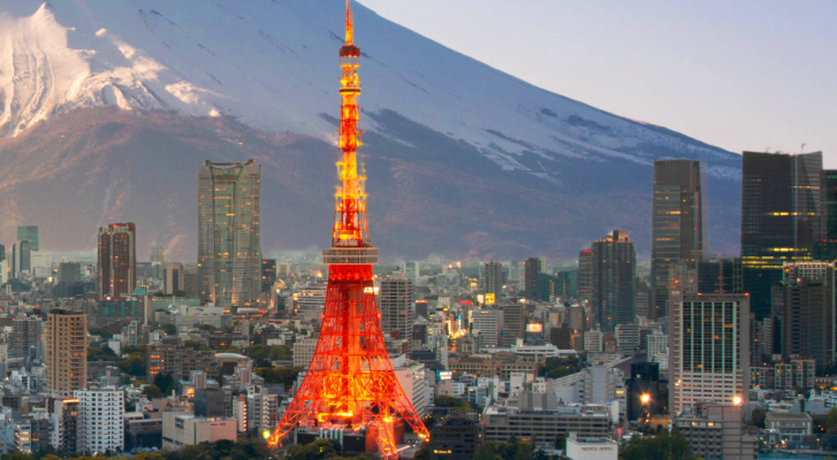 Tokyo Tower covered in lights and surrounded by building and the view of Mt Fuji in  Minato City, Tokyo