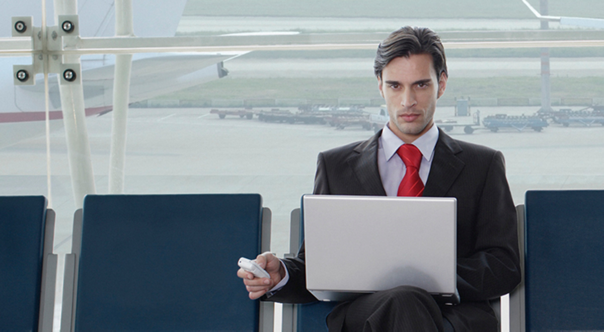 Man working on his laptop while waiting for his flight
