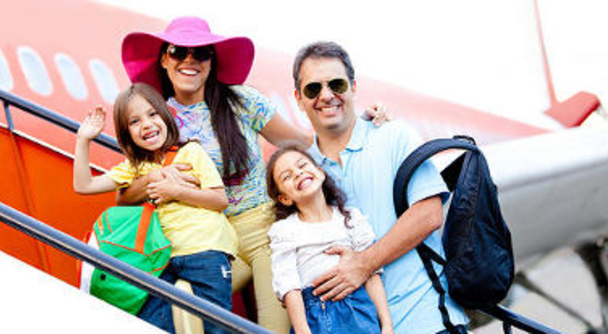 a couple boarding a red and white plane with their two daughters