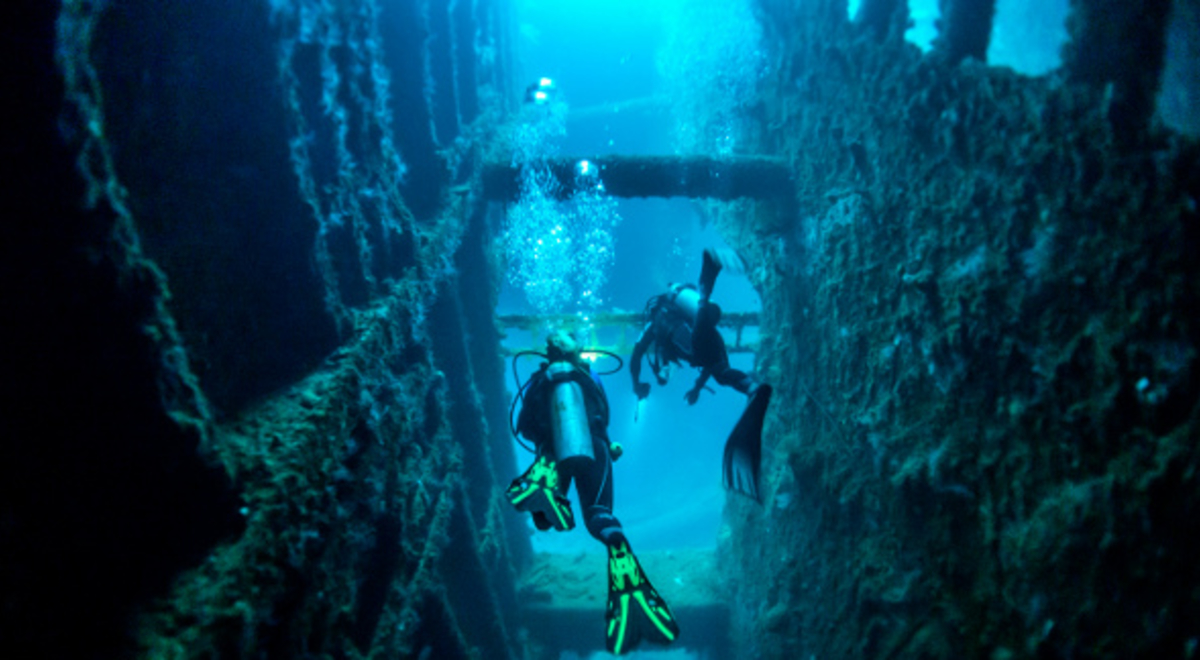 Two scuba divers exploring a ship wreck in Vanuatu