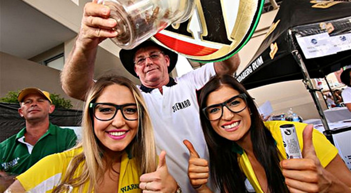 Man holding jar of cockroaches over two girls heads 