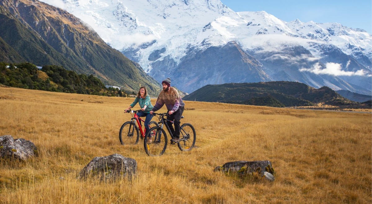 Travellers riding bikes in Mt Cook National Park