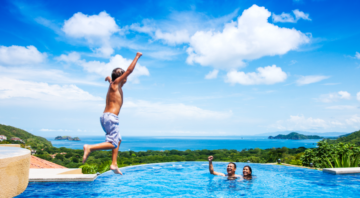Kid jumping into pool while parents cheer him on
