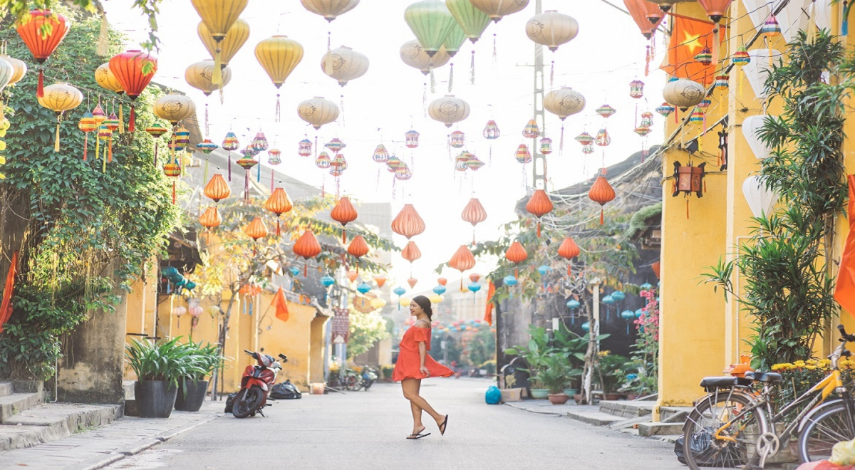 Vietnamese woman in red dress dancing in street with lanturns