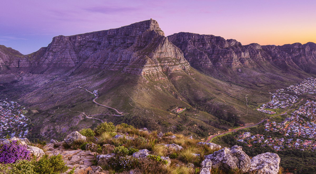 A stunning view of a mountain on an island as the sun sets over the sea
