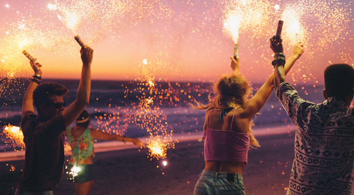 People partying with sparklers on a beach
