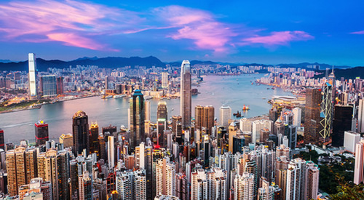 Crowded cityscape and river at dusk