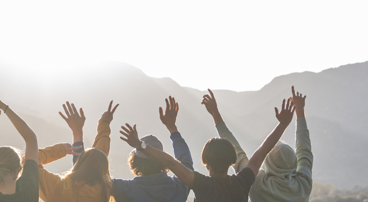 Group of nine admiring the view with their hands in the air 