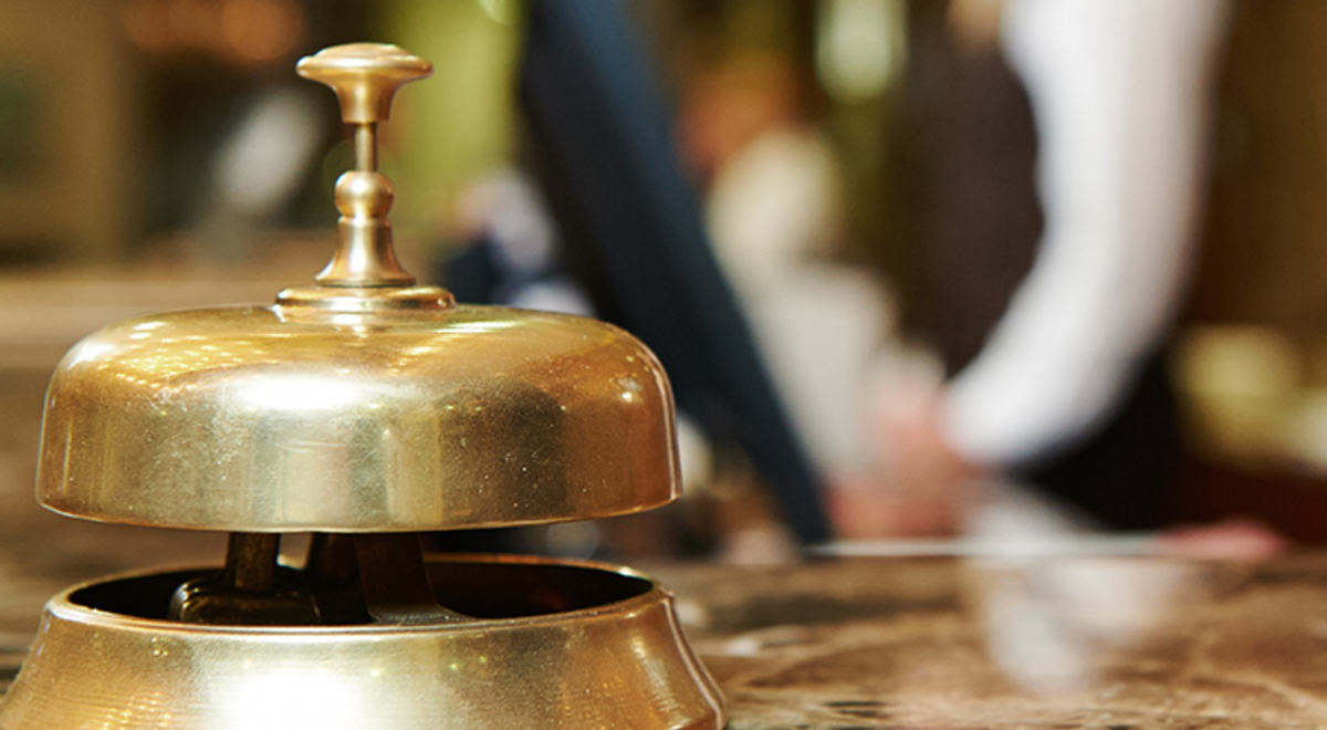 A bell sitting on a concierge desk in a hotel