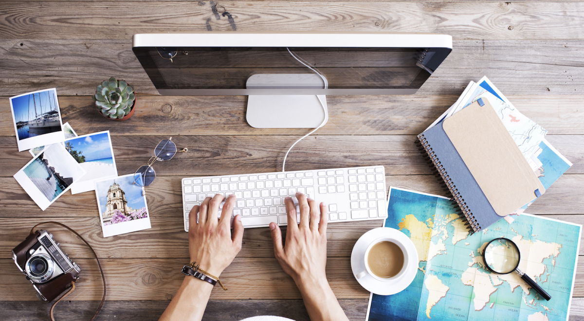 Woman booking holiday online with maps, photos and a journal