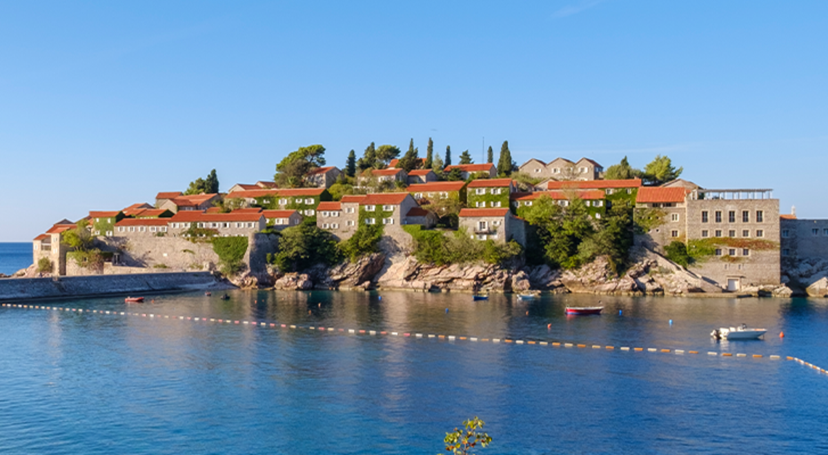 Multiple small houses placed on an island over blue water