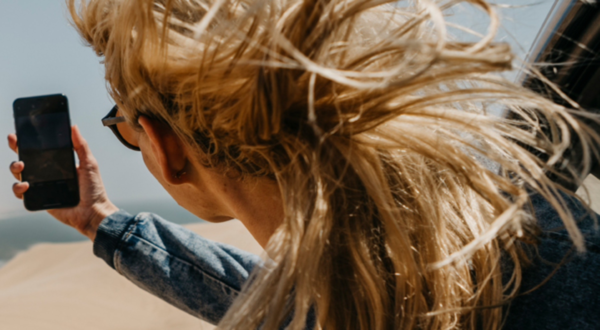 Image of a person taking a picture of sand dunes from a helicopter