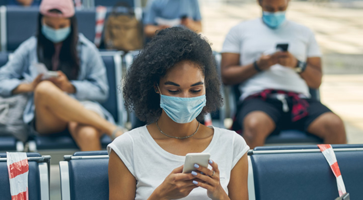 Three young adults waiting at the airport on blue seats 