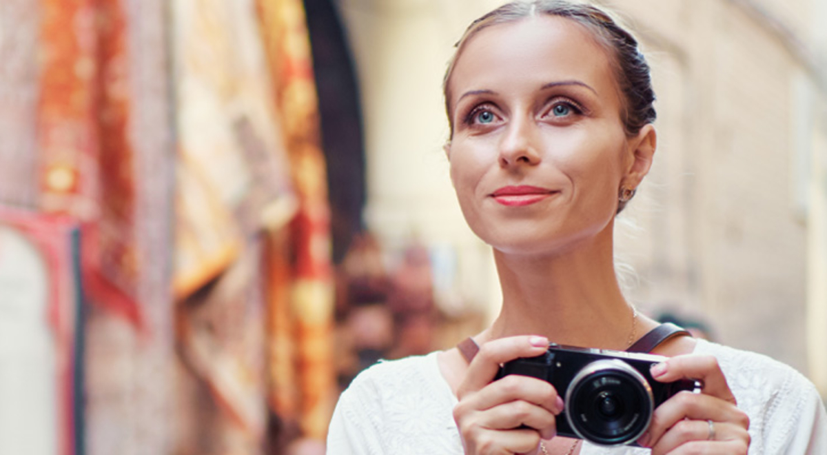 A traveller walking through a city with a camera