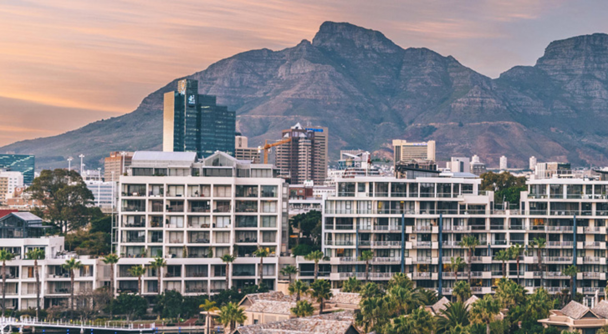 A hotel in a tropical destination with mountains in the background