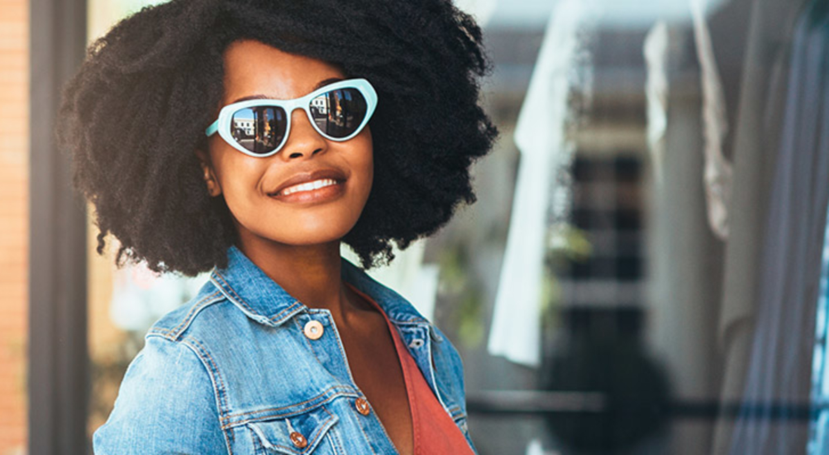 Woman wearing denim jacket and blue glasses 