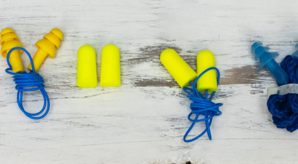 Different colors and shapes of earplugs lined up  on a table