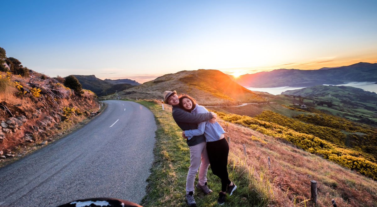 Young couple on road trip near Akaroa, Christchurch, South Island, New Zealand