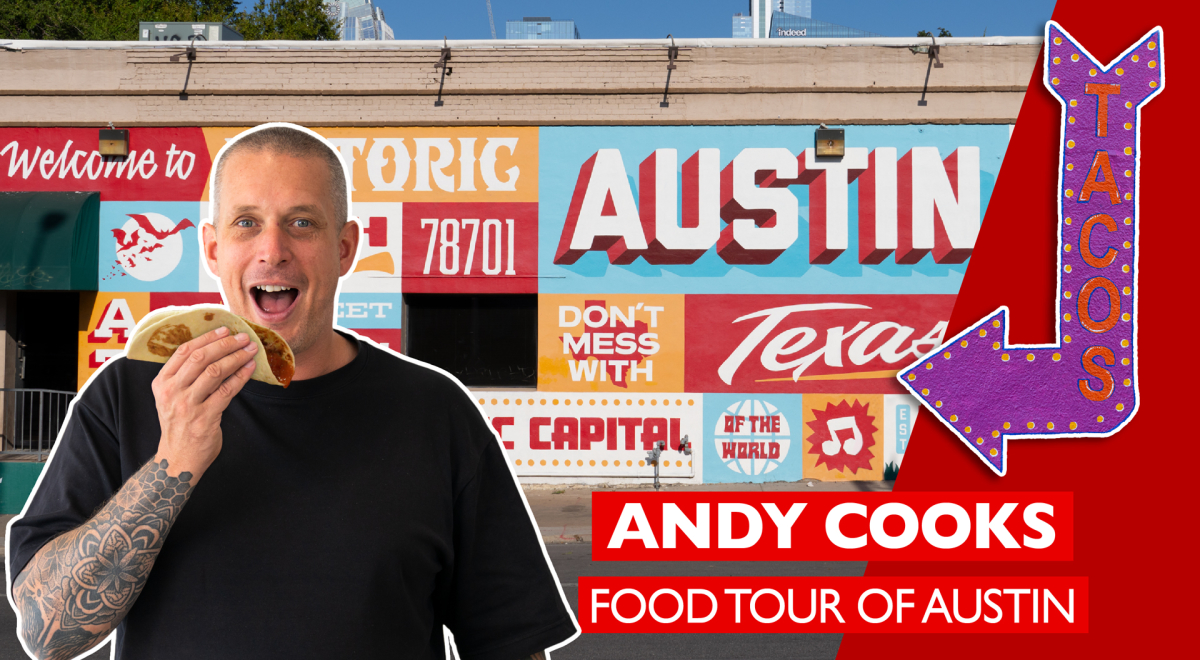 Andy Cooks Standing in front of a sign eating a taco