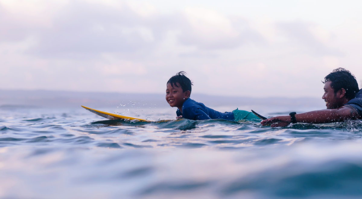 Father and son surfing in Bali