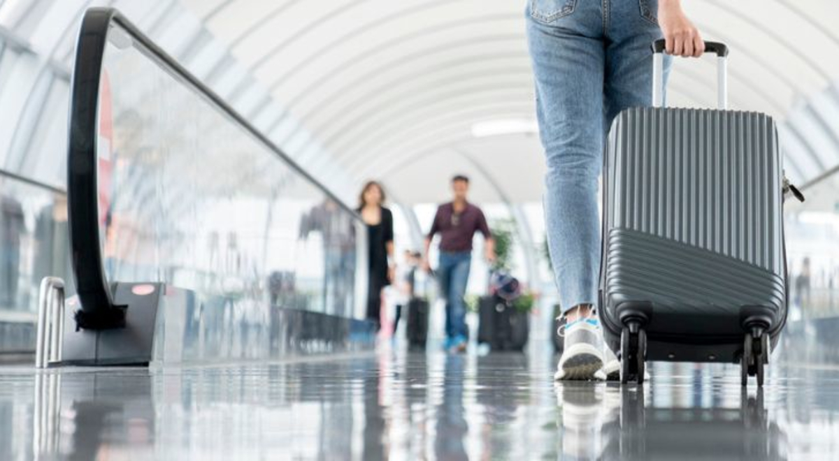 Image of a suitcase being wheeled through airport