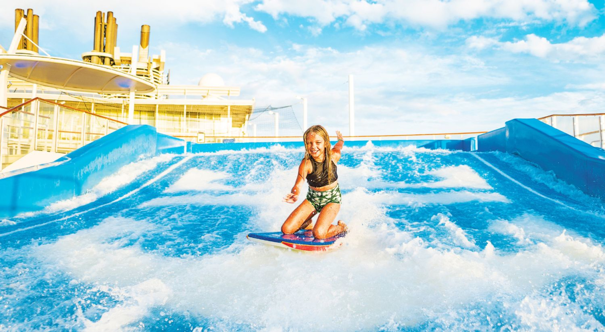 A young girl riding the surf simulator