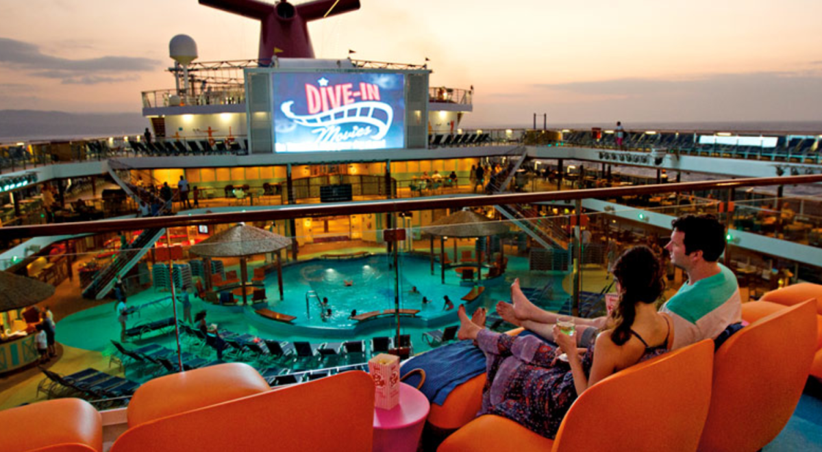 A couple watch outdoor cinema from the top deck of a cruise ship