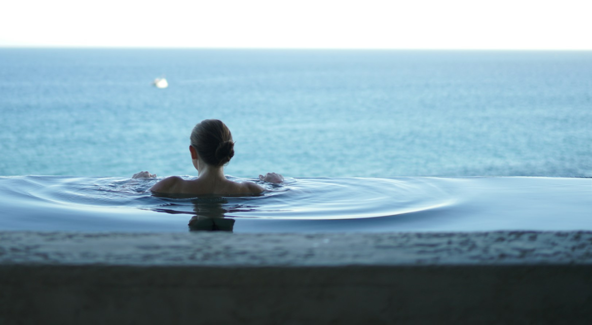A woman relaxes in an infinity pool