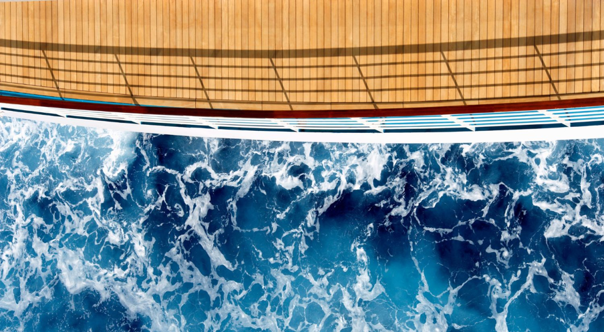 An aerial view to the stern of a cruise ship with disturbed water