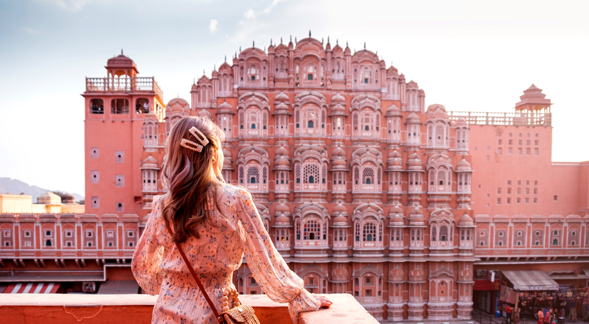 A woman looking at the Hawa Mahal in Jaipur, India