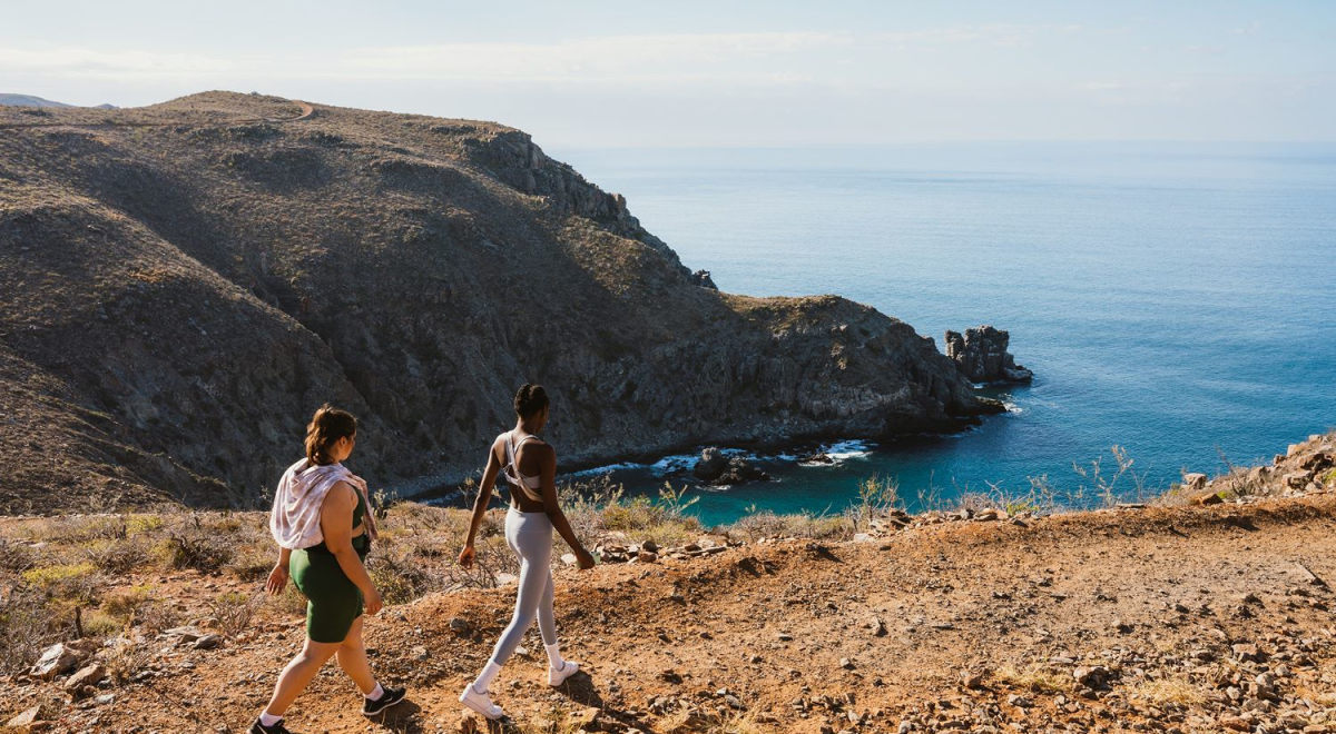Two women walking along the coast in Los Cabos