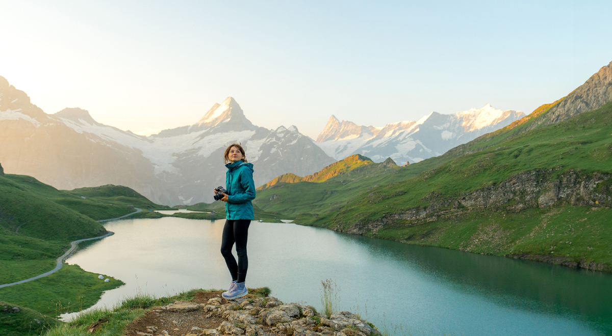 A woman with camera at viewpoint near Lake Bachalpsee in the Swiss Alps