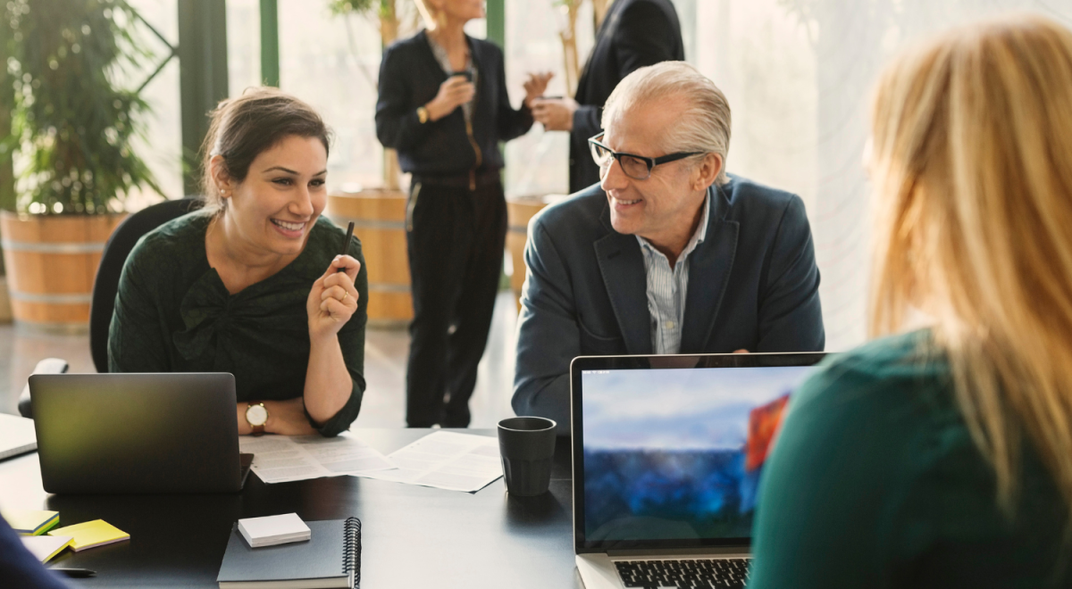 Smiling businesswoman discussing with colleagues in creative office