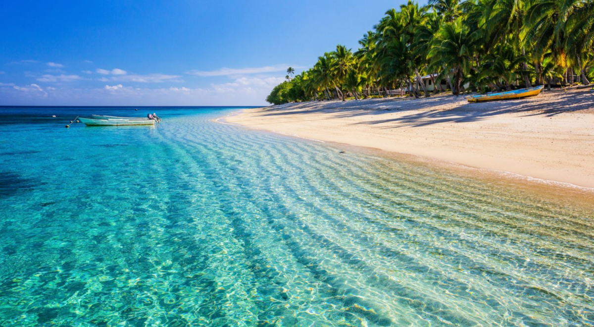 Small waves and clear water on a white sand beach in the South Pacific